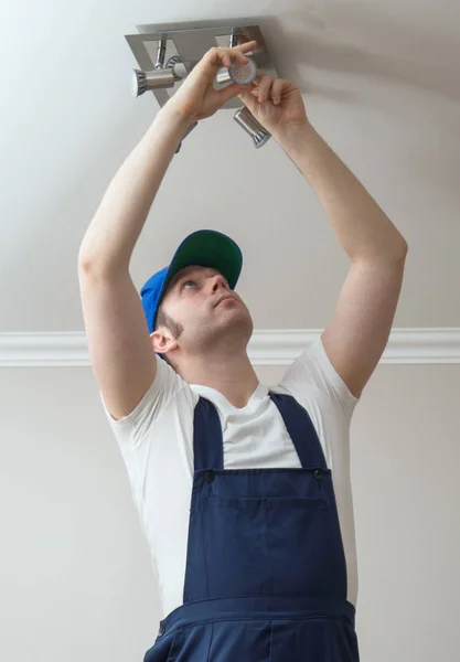 Handsome male electrician changing the light bulb. — Stock Photo, Image