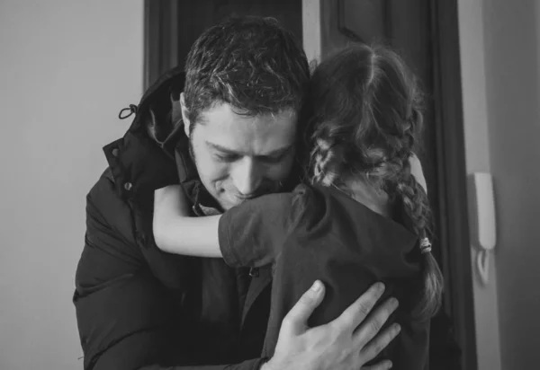 Ο πατέρας αγκαλιάζει την κόρη μετά από μακρύ ταξίδι. Μαύρο και άσπρο. — Φωτογραφία Αρχείου