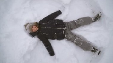 Küçük kız kış döneminde kar melek yapma.