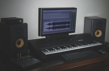 Ev kayıt stüdyosu profesyonel monitörler ve MIDI klavye ile.