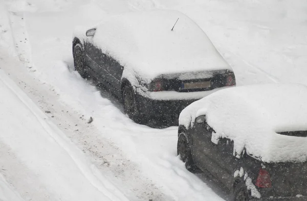 Samochody pokryte śniegiem na ulicy w zimie. — Zdjęcie stockowe