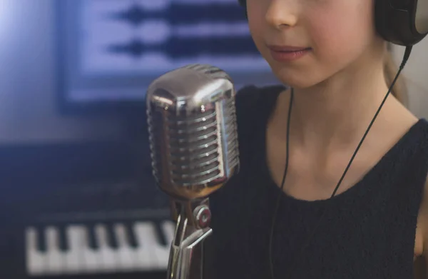 Menina cantando uma música em estúdio de gravação em casa . — Fotografia de Stock