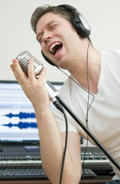 Pohledný muž nahrávání skladby v hudebním studiu. — Stock fotografie
