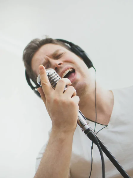 Knappe man van de opname van een lied. Gericht op de microfoon. Ruimte voor uw tekst. — Stockfoto