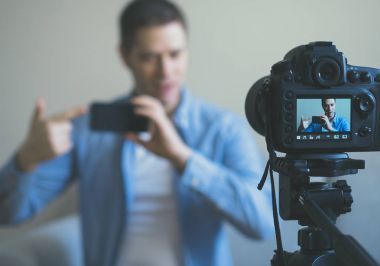 Cep telefonları ile ilgili video blog yaparken adam. Kamera üzerinde odaklama.