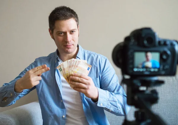 Hombre guapo haciendo video blog sobre ganar dinero . — Foto de Stock