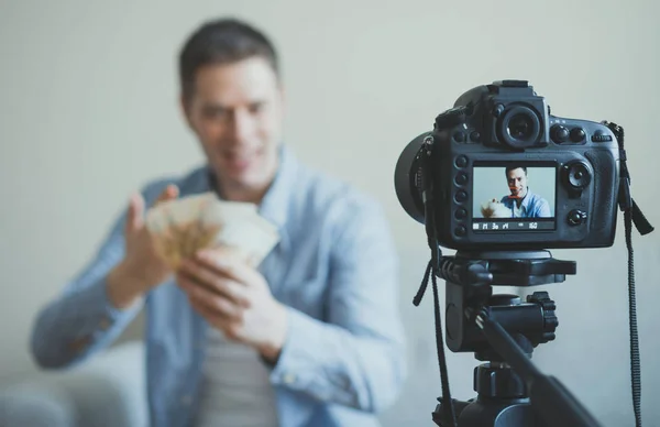 Homme faisant blog vidéo sur les gains d'argent. Focus sur la caméra . — Photo