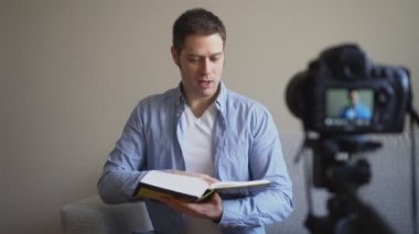 Yakışıklı adam kitap ve eğitim ile ilgili video blog yaparken.