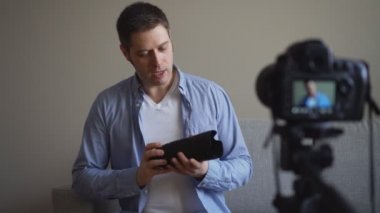 Yakışıklı adam fotoğraf makinesi lensleri hakkında video blogu yapıyor..