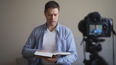 Yakışıklı adam kitap ve eğitim ile ilgili video blog yaparken.