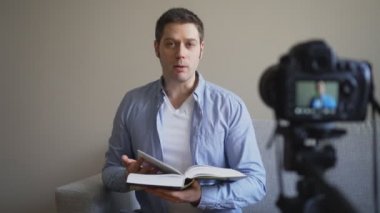 Yakışıklı adam kitap ve eğitim ile ilgili video blog yaparken.