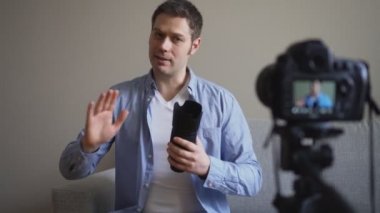 Yakışıklı adam fotoğraf makinesi lensleri hakkında video blogu yapıyor..