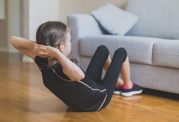 Маленька дівчинка робить вправи для відсутності вдома . — стокове фото