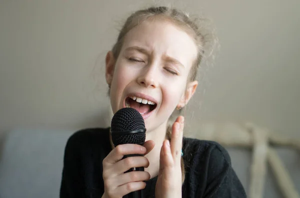Ładny mały dziewczyna śpiewa karaoke w domu. — Zdjęcie stockowe