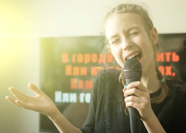 Ładny mały dziewczyna śpiewa karaoke w domu. — Zdjęcie stockowe