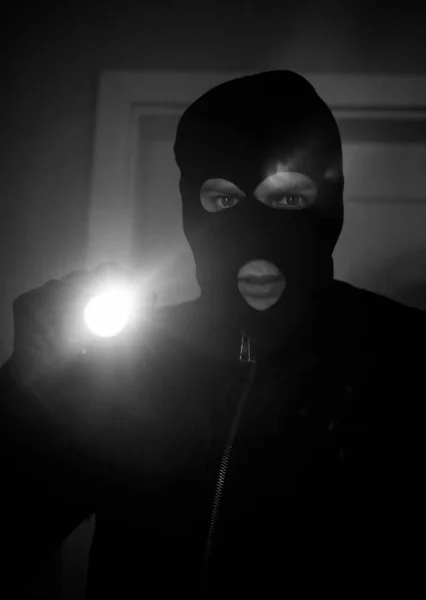 Thief wearing mask with a flashlight in the house. — Stock Photo, Image