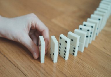 Domino yere yerleştirerek oynayan çocuk.