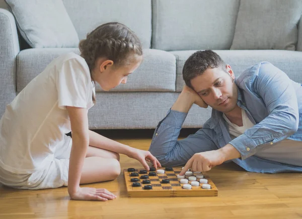 Father and daughter playing checkers board game. — Stock Photo, Image