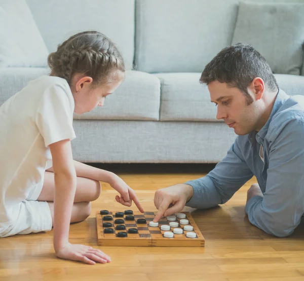 Father and daughter playing checkers board game. — Stock Photo, Image