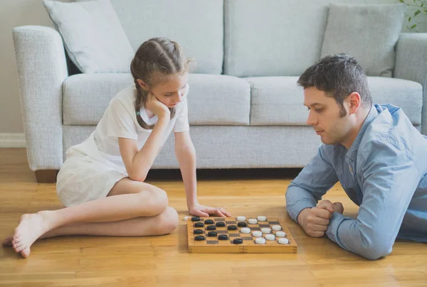 父亲和女儿玩跳棋棋盘游戏. — 图库照片