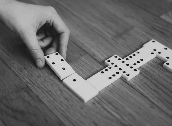 Dítě hrající Domino na podlaze. Černá a bílá. — Stock fotografie