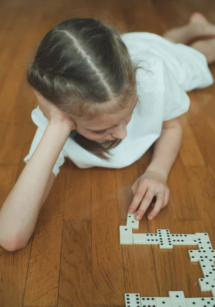 Menina bonito jogar dominó no chão . — Fotografia de Stock