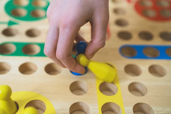 Kind spielt ludo Brettspiel. Nahaufnahme. — Stockfoto