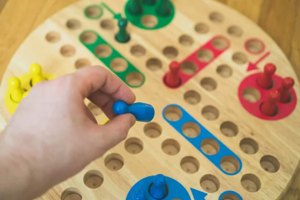 Homme jouant au jeu de société Ludo. Vue rapprochée . — Photo