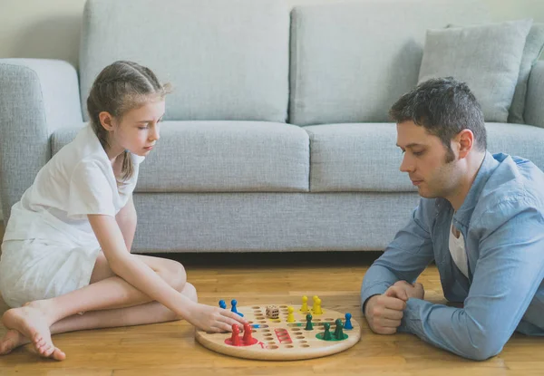 Holčička a její otec hraje ludo. — Stock fotografie