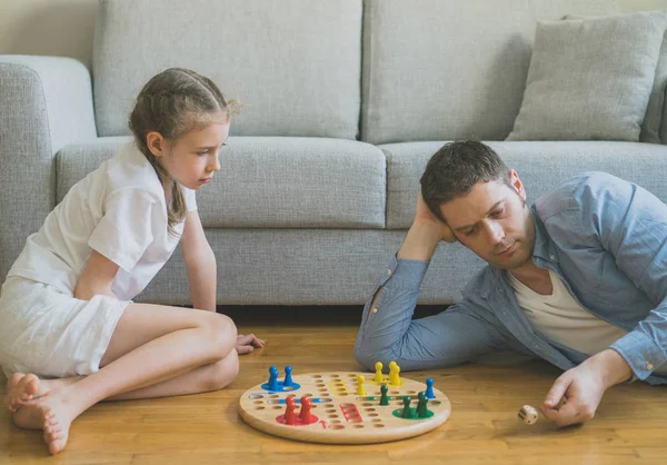 Kleines Mädchen und ihr Vater spielen ludo. — Stockfoto