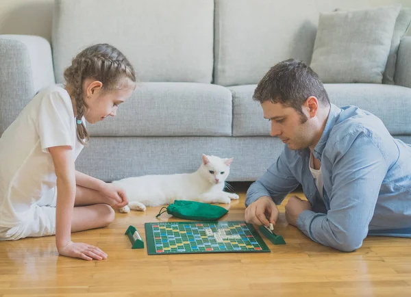 Petite fille et son père jouant scrabble jeu de société . — Photo