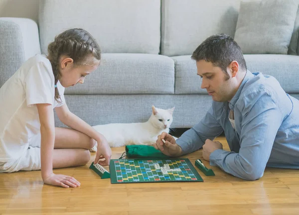 Liten flicka och hennes far spela scrabble brädspel. — Stockfoto