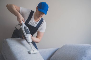 Kanepe ile kuru Buhar temizleyici temizlik Üniformalı erkeklere. Metin için yer.