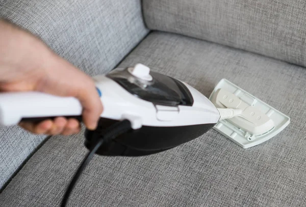 Cleaning fabric of the sofa with a steam cleaner. — Stock Photo, Image