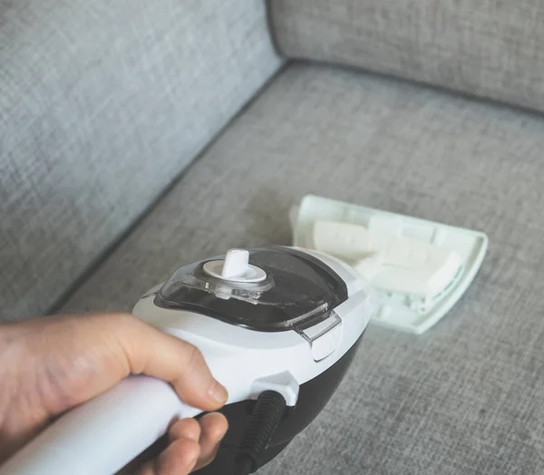 Cleaning fabric of the sofa with a steam cleaner. — Stock Photo, Image