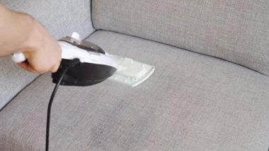 Kumaş koltuk ile bir buhar temizleyici temizlik.