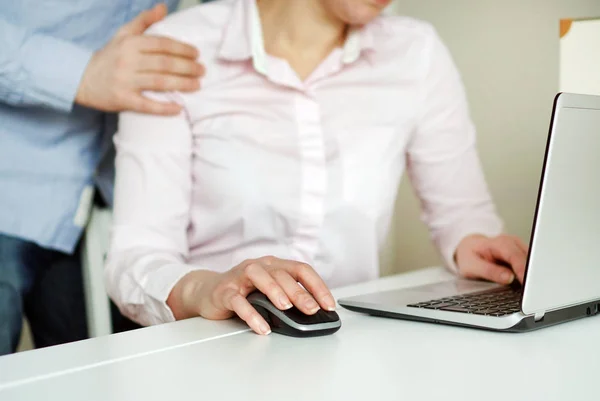 Sexuella trakasserier på arbetsplatsen. Man rörande sekreterarens skuldra. — Stockfoto