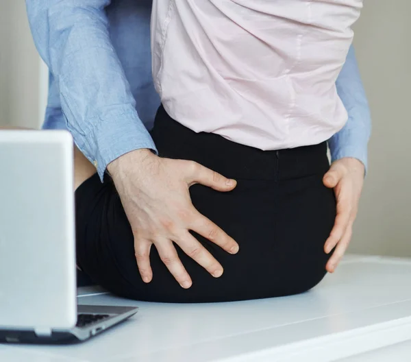 Coquetear sexualmente en el trabajo. Hombre tocando el culo de mujer . — Foto de Stock