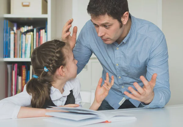 Vater streitet mit Tochter über Buch-Fakten. — Stockfoto