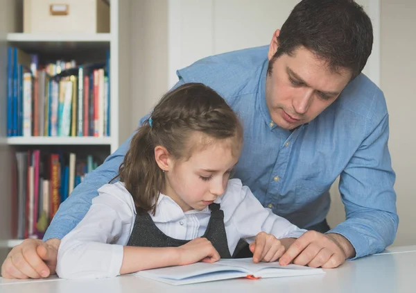 Pai ajudando filha com lição de casa em casa . — Fotografia de Stock