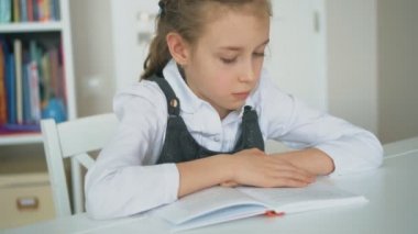 Sevimli küçük kız kitap okuyor. Ağır çekim.