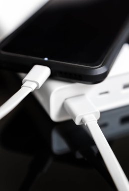 Yansıtılmış yüzeyi beyaz güç banka ile smartphone.
