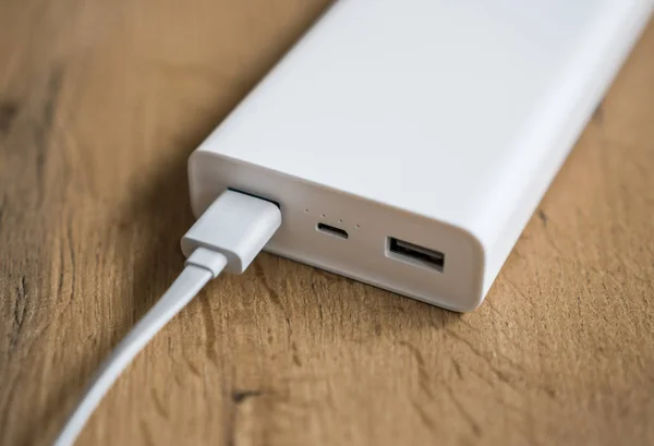 White power bank on wooden surface. Space for your text.