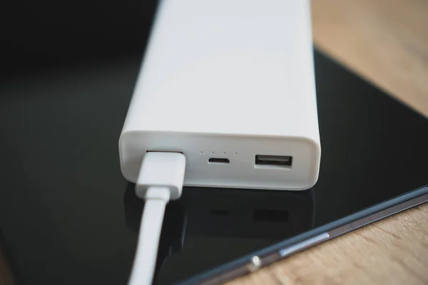 White power bank with tablet pc on wooden surface. — Stock Photo, Image