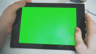 Tablet pc ile yeşil perde tutan el. Chroma anahtar.