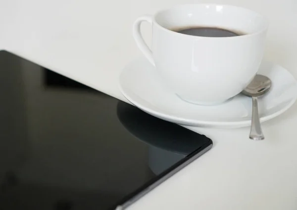 Black tablet pc with cup of coffee on the table. — Stock Photo, Image