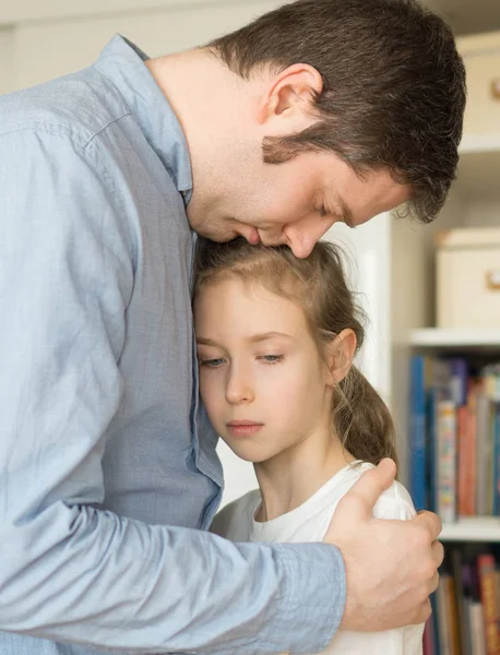 Trauriges kleines Mädchen umarmt ihren Vater. — Stockfoto