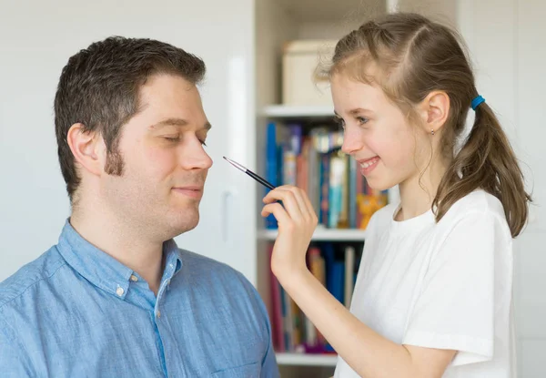 Söt liten flicka gör smink till sin pappa. — Stockfoto