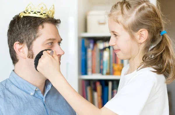 Schattig klein meisje het maken van make-up naar haar vader. — Stockfoto