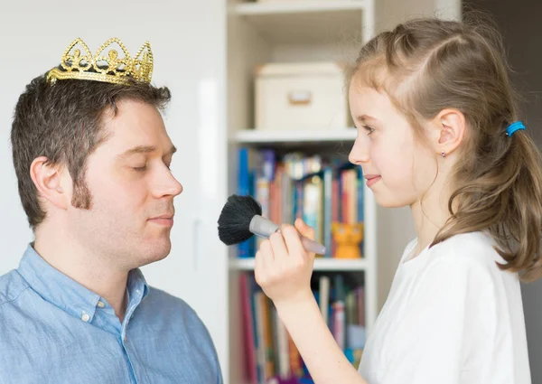 Menina bonito fazendo maquiagem para seu pai . — Fotografia de Stock